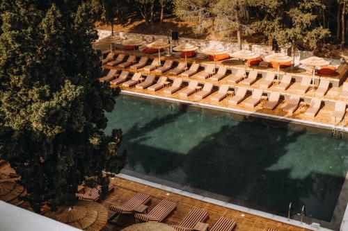 una vista aérea de una piscina con sillas y sombrillas en Cook's Club Ialysos Rhodes, en Ialisos