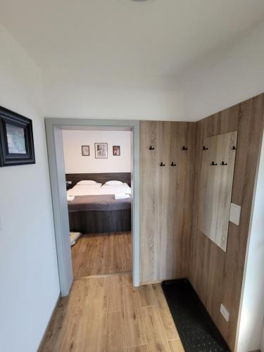 een slaapkamer met een bed en een kamer met houten wanden bij Apartmán U nás in Frymburk