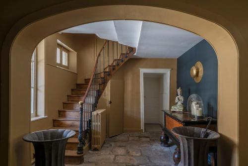 a hallway with a spiral staircase with stools at La Maison Pavie in Dinan