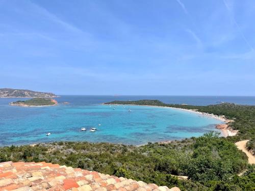 een uitzicht op een strand met boten in het water bij SAN TEODORO PUNTA EST STUPENDO TRILOCALE VISTA MARE in Capo Coda Cavallo