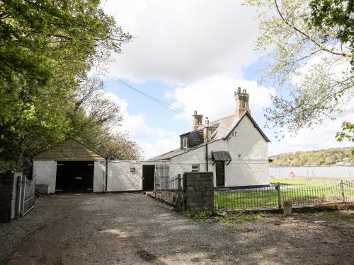 an old white building with a gate in front of it at Bwthyn Siliwen Old Bath House in Bangor