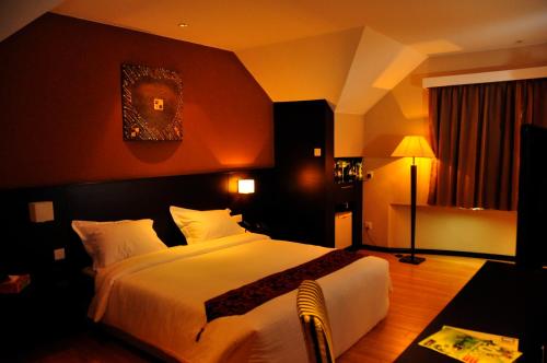 a bedroom with a large white bed in a room at Tat Place Hotel in Kuala Belait