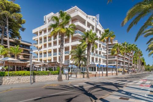 um grande edifício branco numa rua com palmeiras em 4R Casablanca Playa em Salou