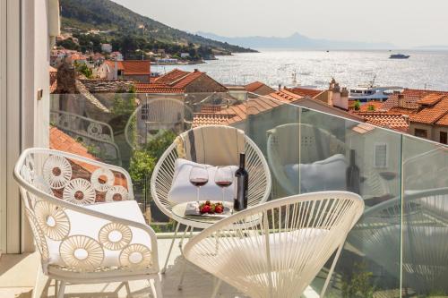 - un balcon avec deux chaises et une table avec des verres à vin dans l'établissement Bol Summer Residence, à Bol