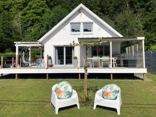 a small white house with two chairs in the yard at Villa Waulsort in Waulsort