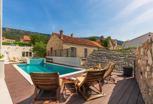 une terrasse avec une table et des chaises ainsi qu'une piscine dans l'établissement Bol Summer Residence, à Bol