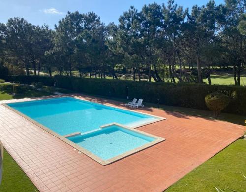 Golf & Praia Del Rey - Óbidos -6 hospedes في أوبيدوس: مسبح كبير جالس على باحة من الطوب