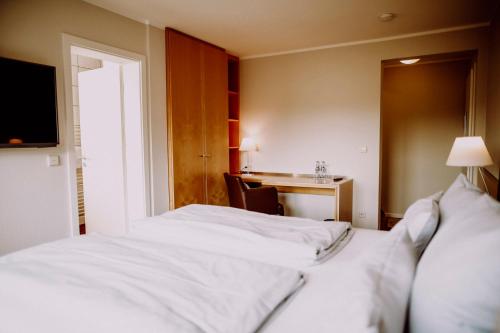 a hotel room with two beds and a desk at Romantik Hotel Schmiedegasthaus Gehrke in Bad Nenndorf