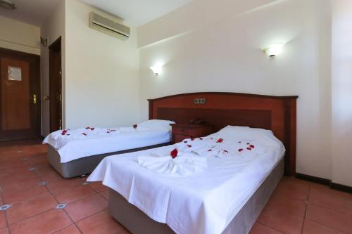 - 2 lits dans une chambre d'hôtel avec des roses dans l'établissement Club Pink Palace Hotel, à Ölüdeniz