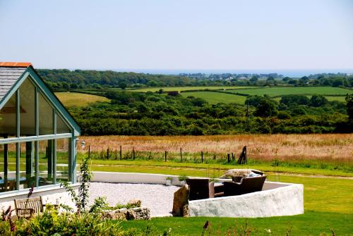 a view of a house with a garden and a field at Fig Tree House in Penryn