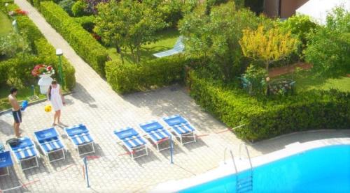 a model of a swimming pool with chairs and a man at B&C Apartments in Lido di Jesolo