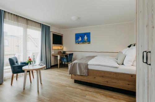 een hotelkamer met een bed en een tafel en stoelen bij Hotel Alter Muschelsaal in Büsum