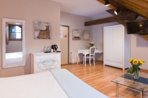 um quarto com uma cama e uma mesa com um vaso de flores em Auberge Communale de Carouge em Genebra