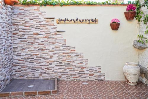 uma escadaria de tijolos com vasos de flores na parede em Casa Recanto da Horta - Casas com EnCanto em Reguengos de Monsaraz