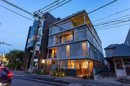 ein hohes Gebäude in einer Stadtstraße in der Unterkunft plat hostel keikyu kamakura wave in Kamakura