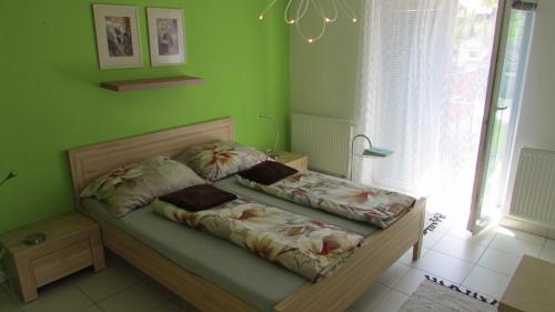 a bedroom with a bed with green walls at apartmány LUHA in Luhačovice