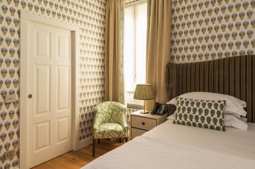 a bedroom with a bed and a chair and a window at Vmaison Brera Milano in Milan