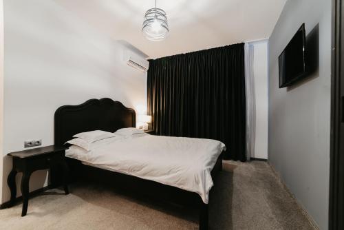 a bedroom with a bed with a black headboard at Meteor Central in Cluj-Napoca