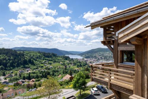 a view from the balcony of a log cabin with a view of a town at Aigle des Neiges 5 étoiles in Gérardmer