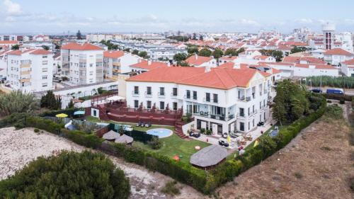 een luchtzicht op een groot wit gebouw met een rood dak bij Hotel Dom Vasco in Sines