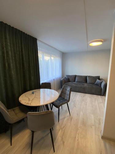 a living room with a table and a couch at ADI Apartamentai in Panevėžys