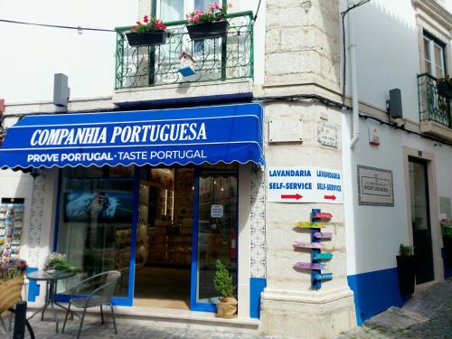 ein Geschäft mit einem blauen Schild an der Seite eines Gebäudes in der Unterkunft Residenza Dutzu - Aparthotel Leiria in Leiria