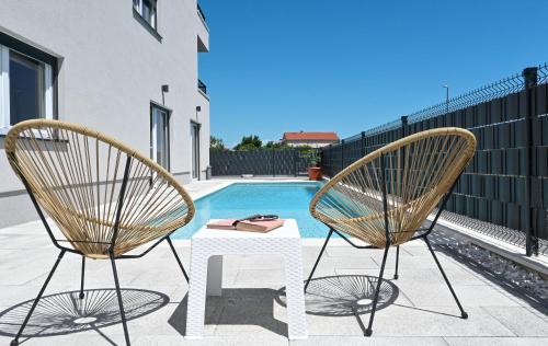 two chairs and a table in front of a pool at Luxury Apartment Maravic with Private Pool in Trogir