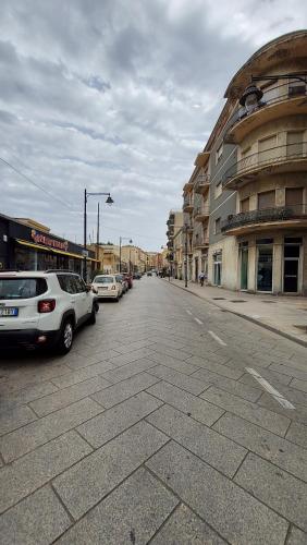 una calle de la ciudad con coches y edificios aparcados en B&B Sa Cannacca, en Olbia