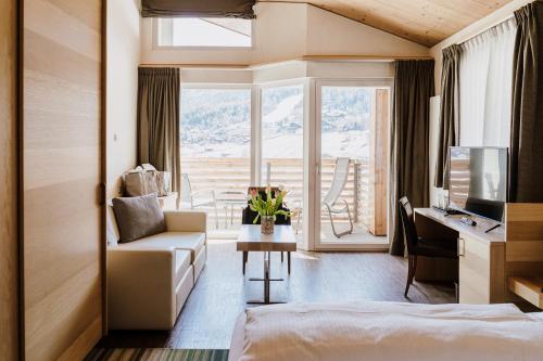 a hotel room with a bed and a desk with a computer at Hotel Lac Salin Spa & Mountain Resort in Livigno