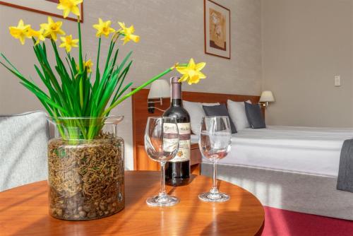 ブワディスワボボにあるHotel Riggaのワイン2杯と花瓶