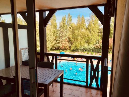 una vista sulla piscina dal balcone di una casa di Bel appartement cosy en résidence avec piscine a Deauville