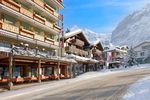 une rue en face d'un bâtiment dans les montagnes dans l'établissement Hotel Central Wolter - Grindelwald, à Grindelwald