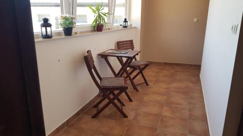 a dining room with two chairs and a table at Végvár Delux apartman in Gyula