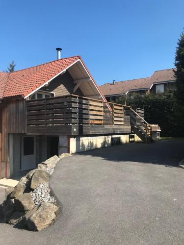 a house with a deck and a driveway at Le Grand Sapin. Maison au calme proche commerces in Gérardmer