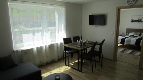 a dining room with a table and chairs and a bedroom at apartmány LUHA in Luhačovice