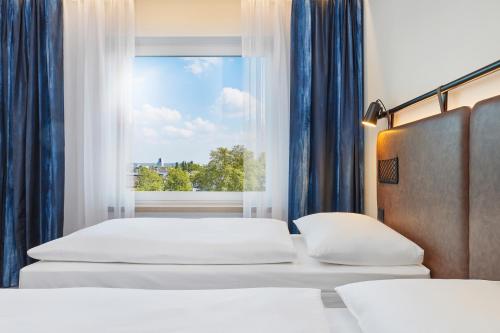 Кровать или кровати в номере H2 Hotel Düsseldorf City