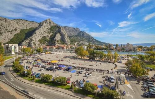 a city with a parking lot with a mountain in the background at Apartman Nela in Omiš