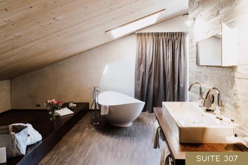 a bathroom with a large tub and a sink at Hotel Lac Salin Spa & Mountain Resort in Livigno