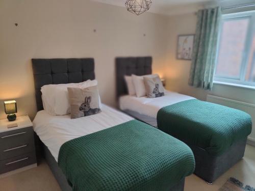 - une chambre avec 2 lits verts et blancs dans l'établissement Frankland - Emsworth Harbour 3 Bedroom House, à Emsworth