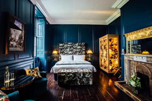 a bedroom with blue walls and a bed and a fireplace at Bellinter House Hotel & Spa in Navan