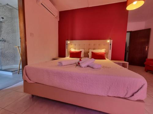 una camera da letto con un grande letto con lenzuola rosa di Só Mar a Vila Nova de Milfontes