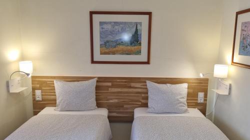 阿尔马达Margarida Guest House - Rooms的两张床位于带两盏灯的墙上。