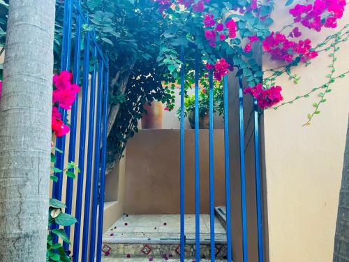 a blue gate with pink flowers on a building at Casa Boho 1 in Sayulita