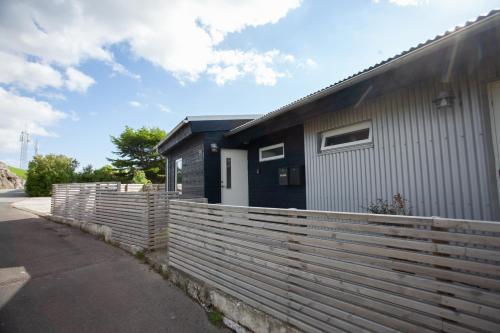 une maison avec une clôture à côté d'un bâtiment dans l'établissement Stadium / Central / Park / Art Gallery, à Tórshavn