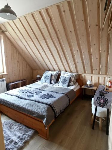 una camera con letto e soffitto in legno di VILLA JAGODOVO Biały Dunajec a Biały Dunajec