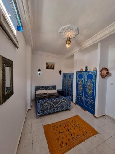 Schlafzimmer mit einem Bett und blauen und weißen Wänden in der Unterkunft Dar Tanger Medina in Tangier