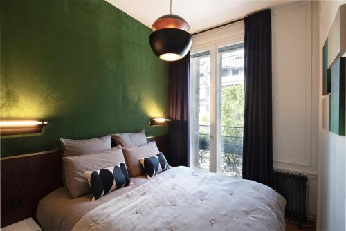 a bedroom with a large bed with a green wall at Joro Living in Paris