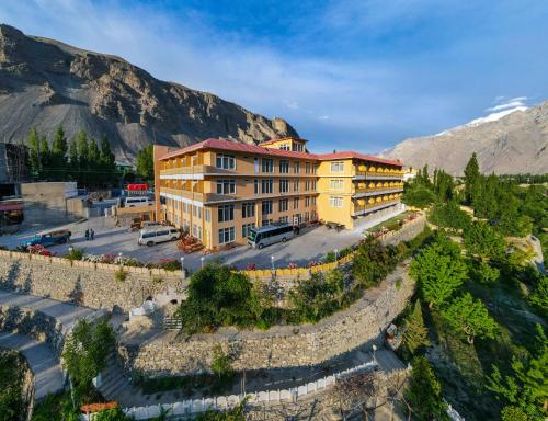 a large yellow building in front of a mountain at LOKAL x Skardu (City Center) in Skardu