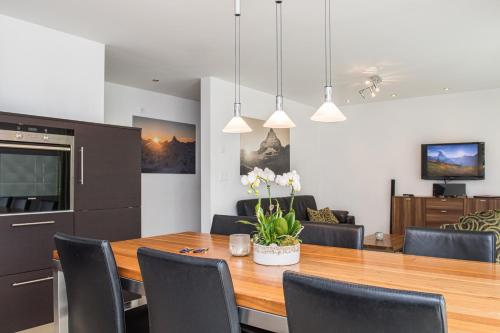 a kitchen and dining room with a wooden table and chairs at Ferienhaus Casa Luna in Zermatt