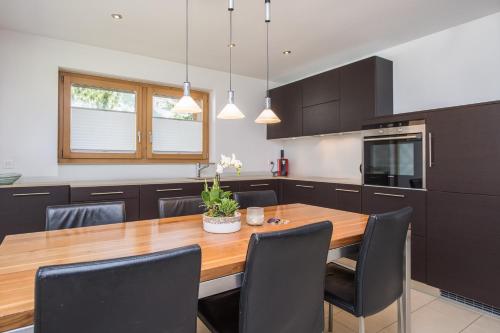 a kitchen with a wooden table and black chairs at Ferienhaus Casa Luna in Zermatt